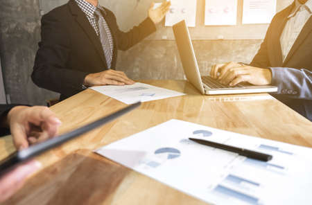 Business executive pointing graph presentation to colleagues in office, during meeting, explaining, consultation.の写真素材