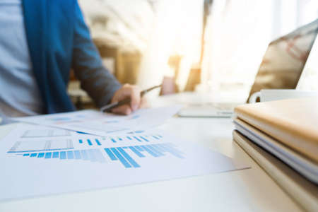 Business man working at office with laptop and documents on his desk. Analyze plans, papers, hands keyboard, business concept.の写真素材