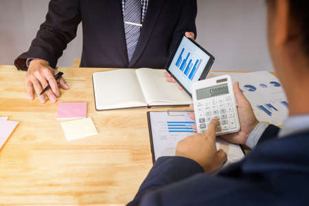 business man and secretary presentation report, two colleague excultive conference presentating report of new plan marketing to development consultating business in company, using calculator.の写真素材