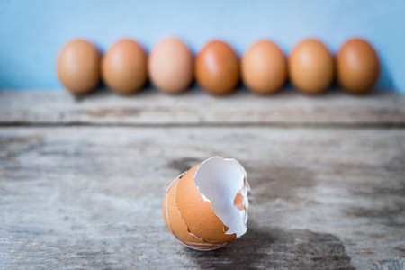 Close-up of egg shell and fresh eggs on wooden background.の写真素材