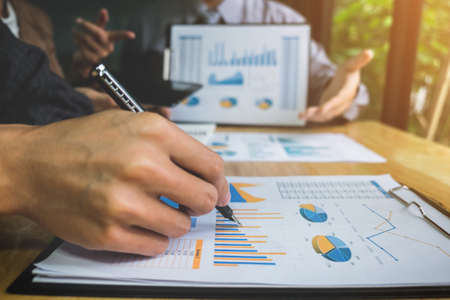 Co working conference, Business team meeting present, investor colleagues discussing new plan financial graph data on office table with laptop and digital tablet, Finance, accounting, investment.の写真素材