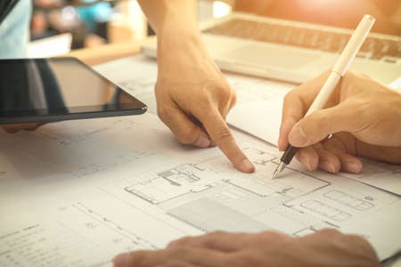 Image of engineer or architectural project, two engineering discussing and working on blueprint with...