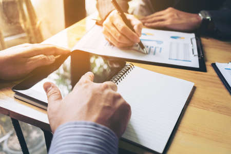 Co working conference, Business team meeting present, investor colleagues discussing new plan financial graph data on office table with laptop and digital tablet, Finance, accounting, investment.の写真素材