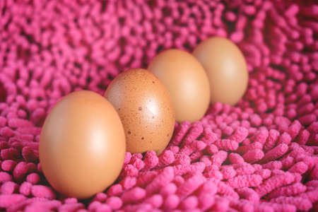 Close-up of Egg with dots and many fresh eggs on Pink fabric background.の写真素材