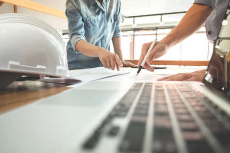 Image of engineer or architectural project, two engineering discussing and working on blueprint with...