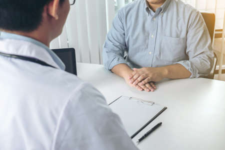 Close up of doctor filling up an history form while consulting patient and recommend treatment methods and how to rehabilitate the body.の写真素材