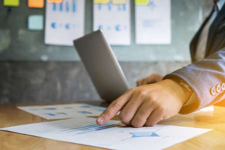 Business executive pointing graph presentation to colleagues in office, during meeting, explaining, consultation.の写真素材