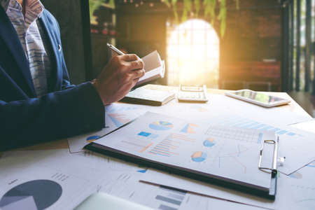 Business team meeting working with new startup project, discussion and analysis data the charts and graphs. Digital tablet calculator, laptop computer using, Business finances and accounting concept.の写真素材