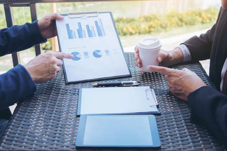 Co working conference, Business team meeting present, investor executive colleagues discussing new plan financial graph data on outdoors office table with laptop and tablet, Finance, accounting, investment.の写真素材