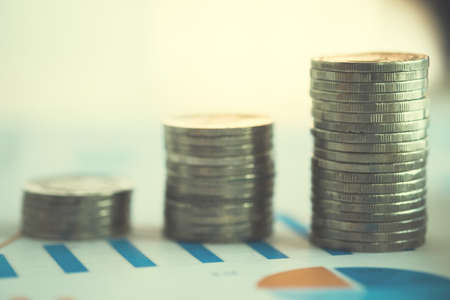 financial banking stock spreadsheet with stack of coin and background on accountant data, growth rate, finance, saving, investment, business and banking concept.の写真素材