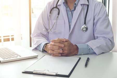 Close up of doctor filling up an history form while consulting patient and think about finding a cure for a diagnosis, treatment methods to rehabilitate the body.のeditorial素材
