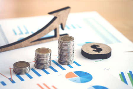 Financial banking stock spreadsheet with stack of coin and background on accountant data, growth rate, finance, saving, investment, business and banking concept.のeditorial素材