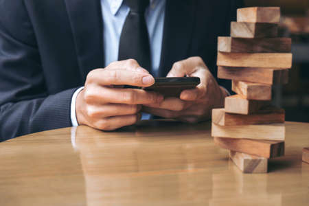 Alternative risk concept, plan and strategy in business, Risk To Make Buiness Growth Concept With Wooden Blocks, Images of hand of businesspeople placing and pulling wood block on the tower.の写真素材