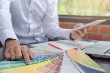 Creative creativity graphic designer working with graphics tablet,laptop and smart phone, colour chart at workplace on wooden desk , colour ideas style concept.の写真素材