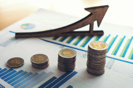 Financial banking stock spreadsheet with stack coin and pen, accountant data, growth rate, finance, saving, investment, business and banking concept.の写真素材