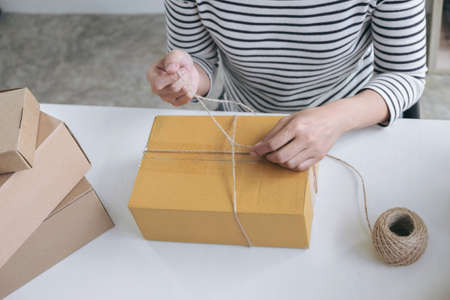 Internet online shopping concept, Young seller woman preparing package to be sent Mail transportation, service network connection market, technology on global, Order online for customer convenience.の写真素材