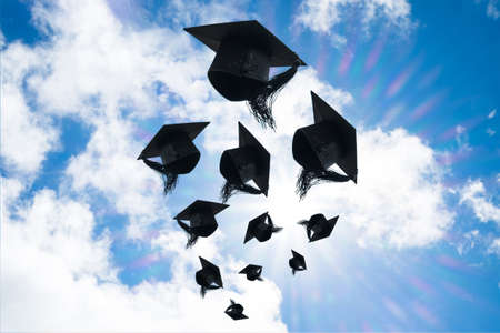 Graduation day, Images of graduation Caps or hat throwing in the air with sunshine day on blue sky...