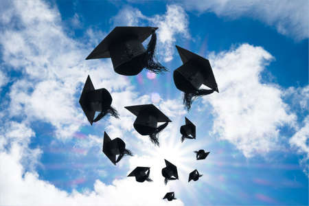 Graduation day, Images of graduation Caps or hat throwing in the air with sunshine day on blue sky background, Happiness feeling, Commencement day, Congratulation, Ceremony.の写真素材