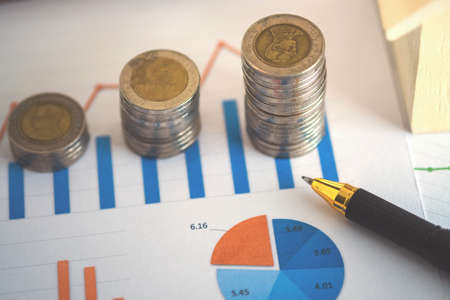 financial banking stock spreadsheet with stack of coin, house and pen on accountant data, growth rate, finance, saving, investment, business and banking concept.の写真素材