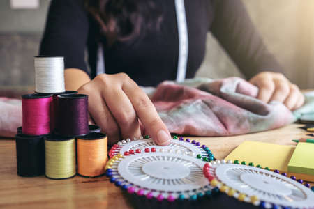 Young woman dressmaker or designer working as fashion designers, Select the needle to the sewing...