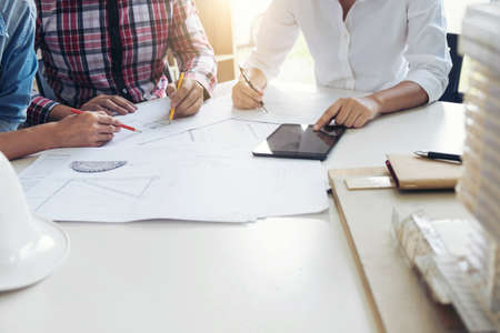 Architect working on blueprint, Engineer meeting working with partner colleagues and engineering tools for architectural project, Construction concept.の写真素材