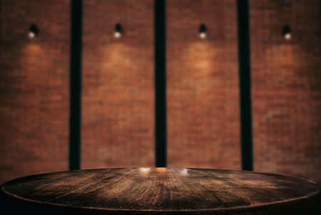 Empty wooden table and blur background of abstract in front of wall texture or old brick wall can be...