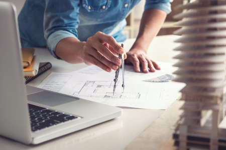 Architect working on blueprint, Engineer working with engineering tools for architectural project on...