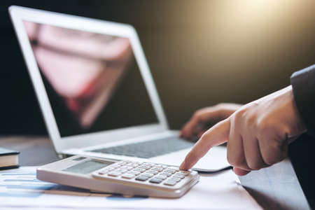 Professional business woman working with calculator, Doing finance on laptop, document graph and analysis business strategy to development profit.の写真素材