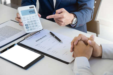 Businessman being analysis and making the decision a car insurance policy, Agent man is using calculator to presentation detail and waiting for his reply to finish.の写真素材