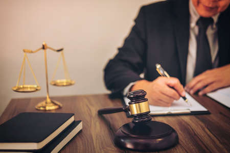 Gavel on wooden table and Lawyer or Judge working with agreement in Courtroom theme, Justice and Law...