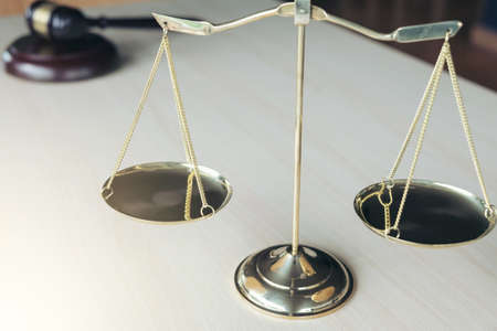Close up of scales of justice and gavel on wooden table in a courtroom striking, Law and justice concept.の写真素材