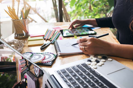 Young woman dressmaker or designer working as fashion designers and drawing sketches for clothes profession and job occupation, Fashion Designer Stylish Concept.の写真素材