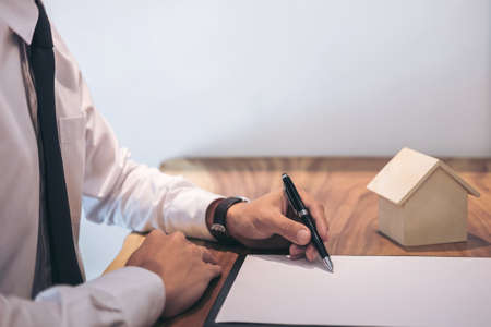 Man sign a home insurance policy on home loans, Businessman signing contract insurance.