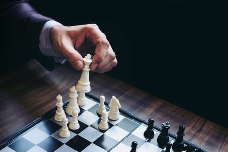Close up of hands confident businessman colleagues playing chess game to development analysis new strategy plan, leader and teamwork concept for success.の写真素材