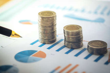 financial banking stock spreadsheet with stack of coin and pen on accountant data, growth rate, finance, saving, investment, business and banking concept.の写真素材