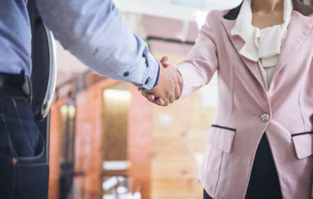 Two businesspeople shaking hands during a meeting in the office, success, dealing, greeting & business partner concepts - selective focus.の写真素材