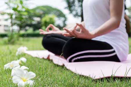Young attractive asian girl practice yoga and relax in the park, healthy concept.の写真素材