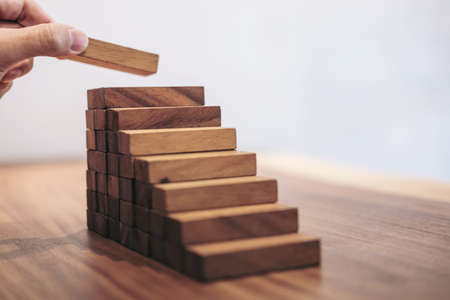 Alternative risk concept, plan and strategy in business, Risk To Make Business Growth Concept With Wooden Blocks, hand of man has piling up and stacking a wooden block.の写真素材