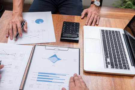 Two confident executives business colleagues meeting and discussing ideas of project about company offer, they is pointing on a contract and giving explanations, team of successful business people.の写真素材