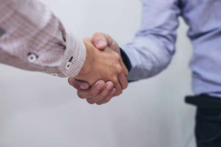 Two businesspeople shaking hands during a meeting in the office, success, dealing, greeting & business partner concepts - selective focus.の写真素材