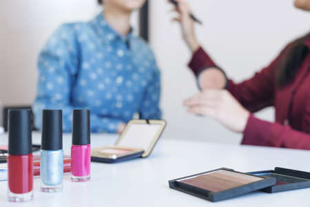 Happy smiling elegant woman or beauty blogger with brush on recording video while review product...