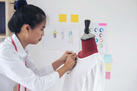 Young woman dressmaker or designer working as fashion designers measure and Repairing clothes and...