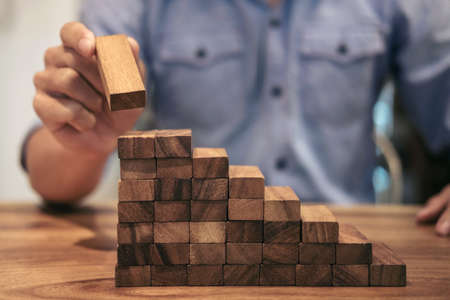 Alternative risk concept, plan and strategy in business, Risk To Make Business Growth Concept With Wooden Blocks, hand of man has piling up and stacking a wooden block.の写真素材