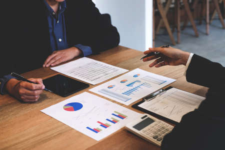 Two businessmen at work, Business crew working with new startup financial project plan,man and woman discussion information with laptop and digital tablet in a modern business lounge,Selective Focus.の写真素材