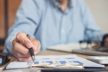 Professional businessman working at workplace with report, Doing finance on laptop, document graph and analysis business strategy to development profit.の写真素材