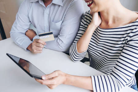 Two people using tablet and credit/debit card register payments online shopping and customer service...