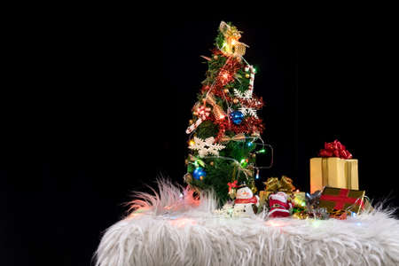 Christmas holiday background with decorated christmas tree, santa claus and gift boxes on black background. New Year Frame for your text.の写真素材