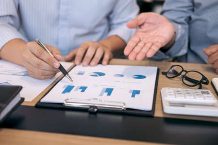 Business team two executive colleagues discussing and analysis working Financial investment on calculator with calculate on tablet Analyze business and market growth on financial document data graph.の写真素材