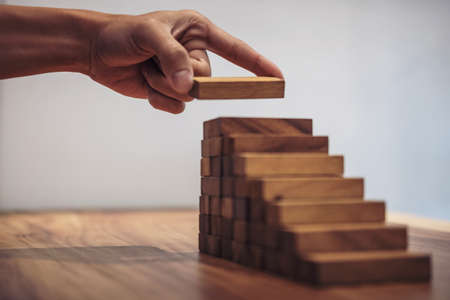 Alternative risk concept, plan and strategy in business, Risk To Make Business Growth Concept With Wooden Blocks, hand of man has piling up and stacking a wooden block.の写真素材