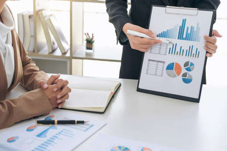 Business team meeting present, investor executive colleagues discussing new plan financial graph data on office table with laptop and tablet, Finance, accounting, investment.の写真素材